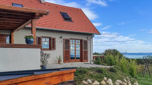 Panorámás, Balatoni ingatlan, Üzleti lehetőségek.  A 2021-ben épült, újszerű állapotban lévő ingatlan egy 3857m2-es bekerített kis szőlőbirtokon fekszik, amely minden pontjáról egyedülálló, elvehetetlen panorámát kínál a Balatonra, a zánkai öbölre és a Hegyestűre.